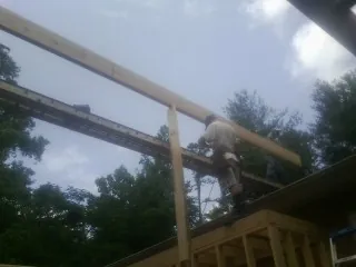 Carpenter setting a ridge beam over a new addition frame — Ice Dam Removal by Roofing Brothers in Los Alamos