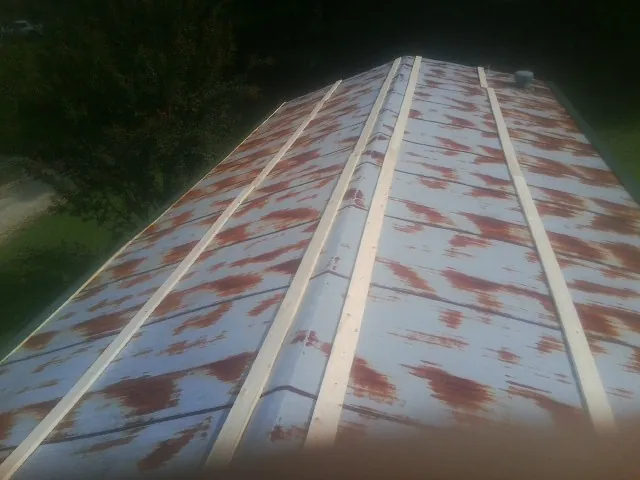 Rusted metal roof panels with new wood purlins before replacement — Storm Damage Roof Repair in Los Alamos by Roofing Brothers
