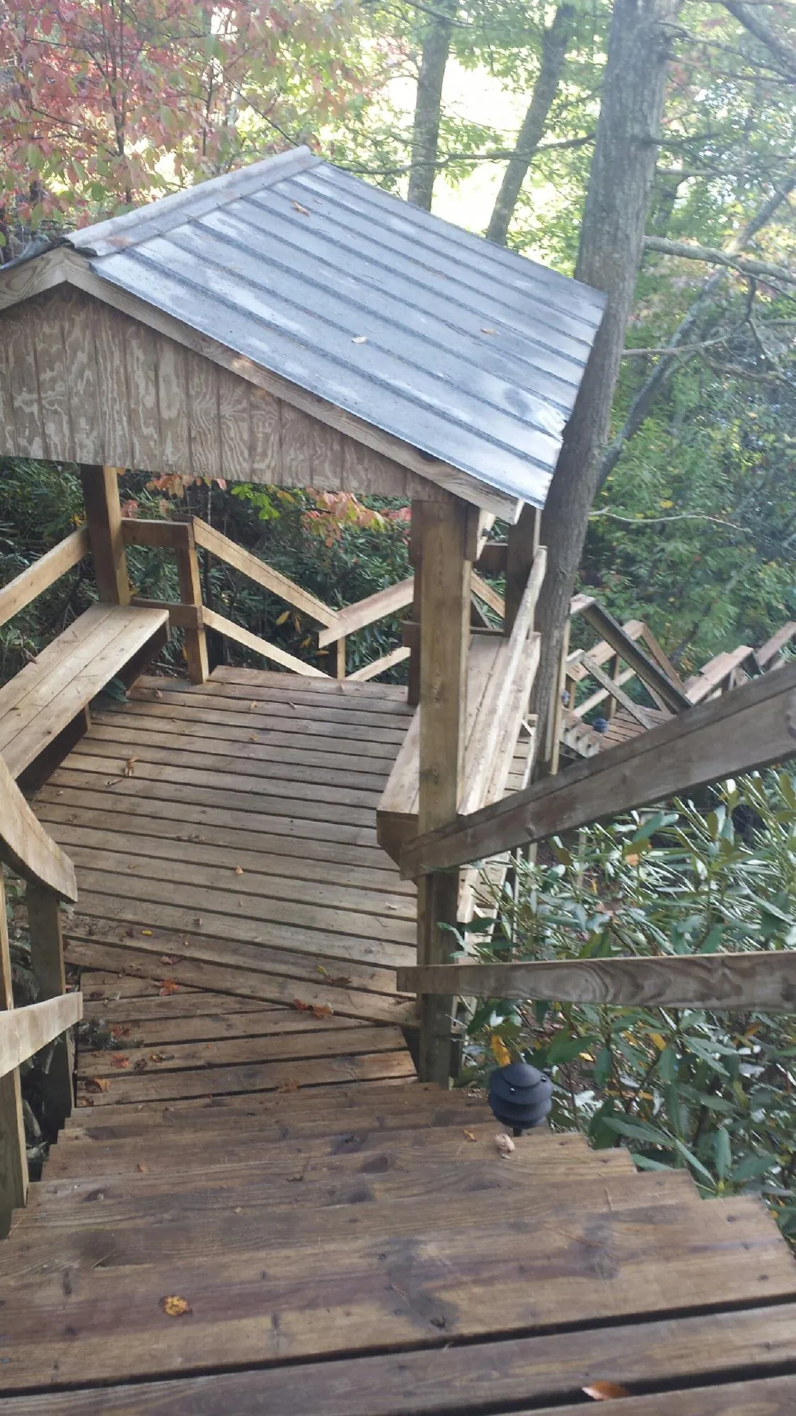 Metal roofed shelter over wooden steps on a wooded walkway — Skylight Repair & Installation work by our crew in Los Alamos