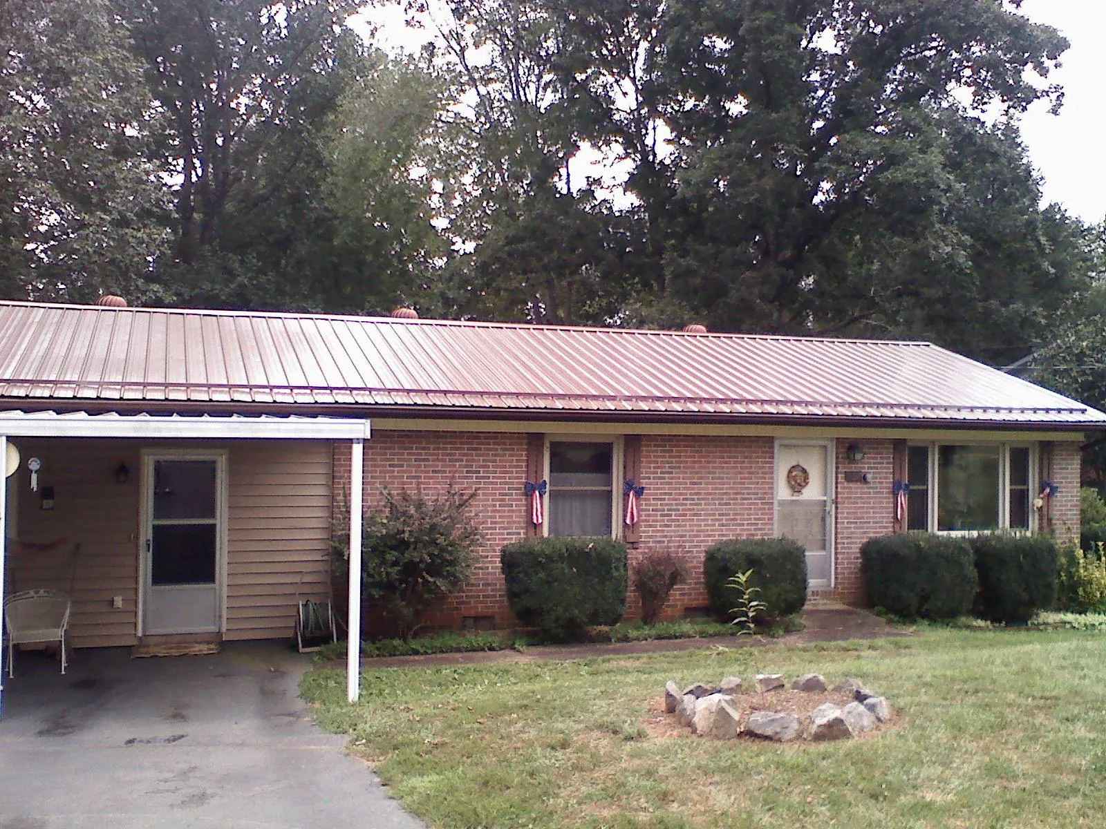 Bronze metal roof and carport on a brick ranch home — Roof Repair work by our crew in Los Alamos
